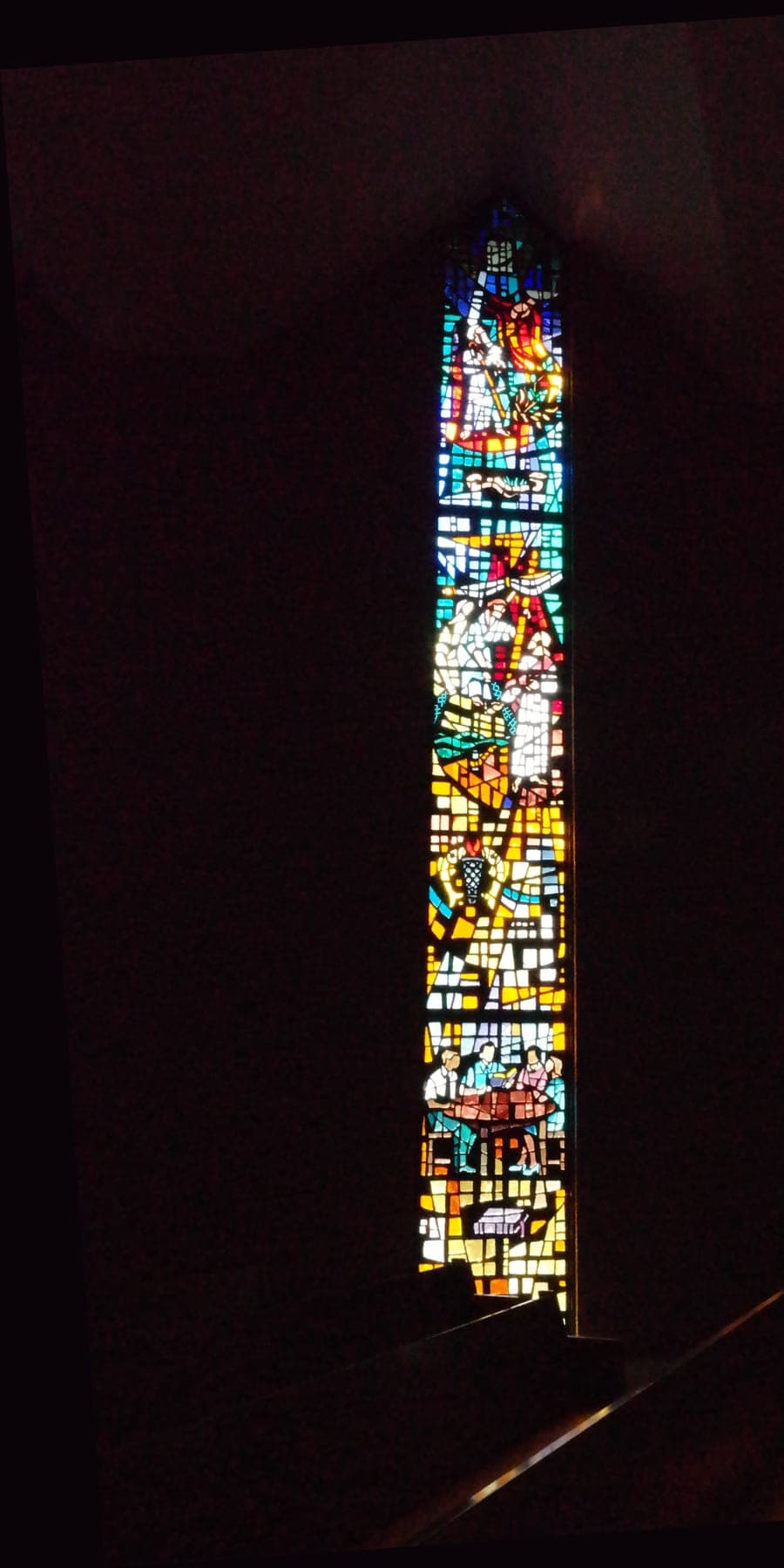 A sanctuary stained-glass window glowing in the dark